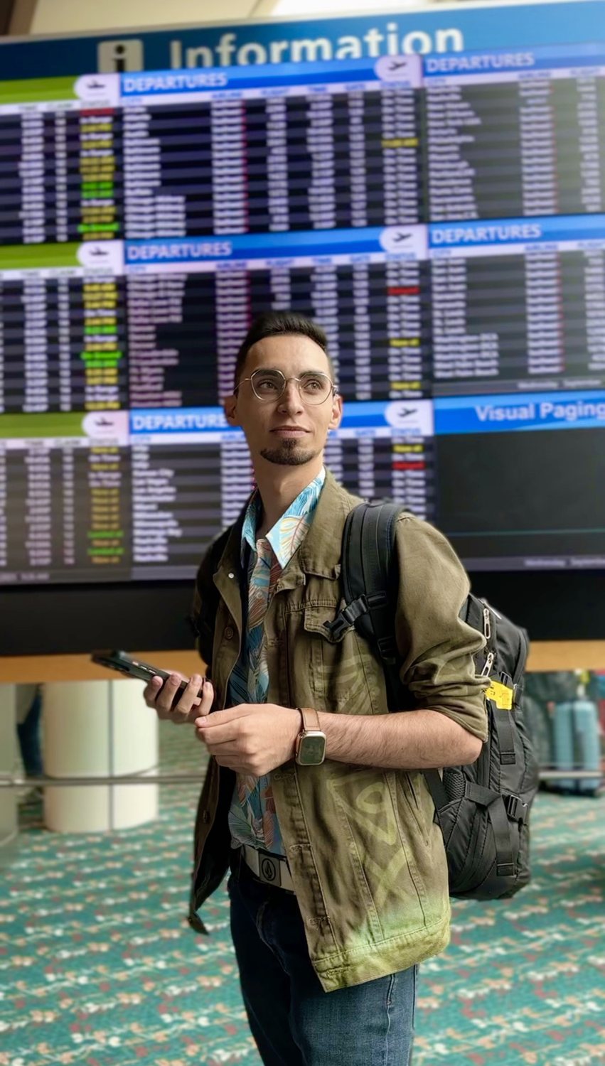Joseluis en el aeropuerto frente a la pantalla de vuelos